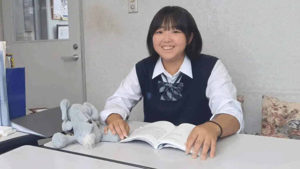 高校生が英語の参考書を開いてレッスンを受けている写真です。